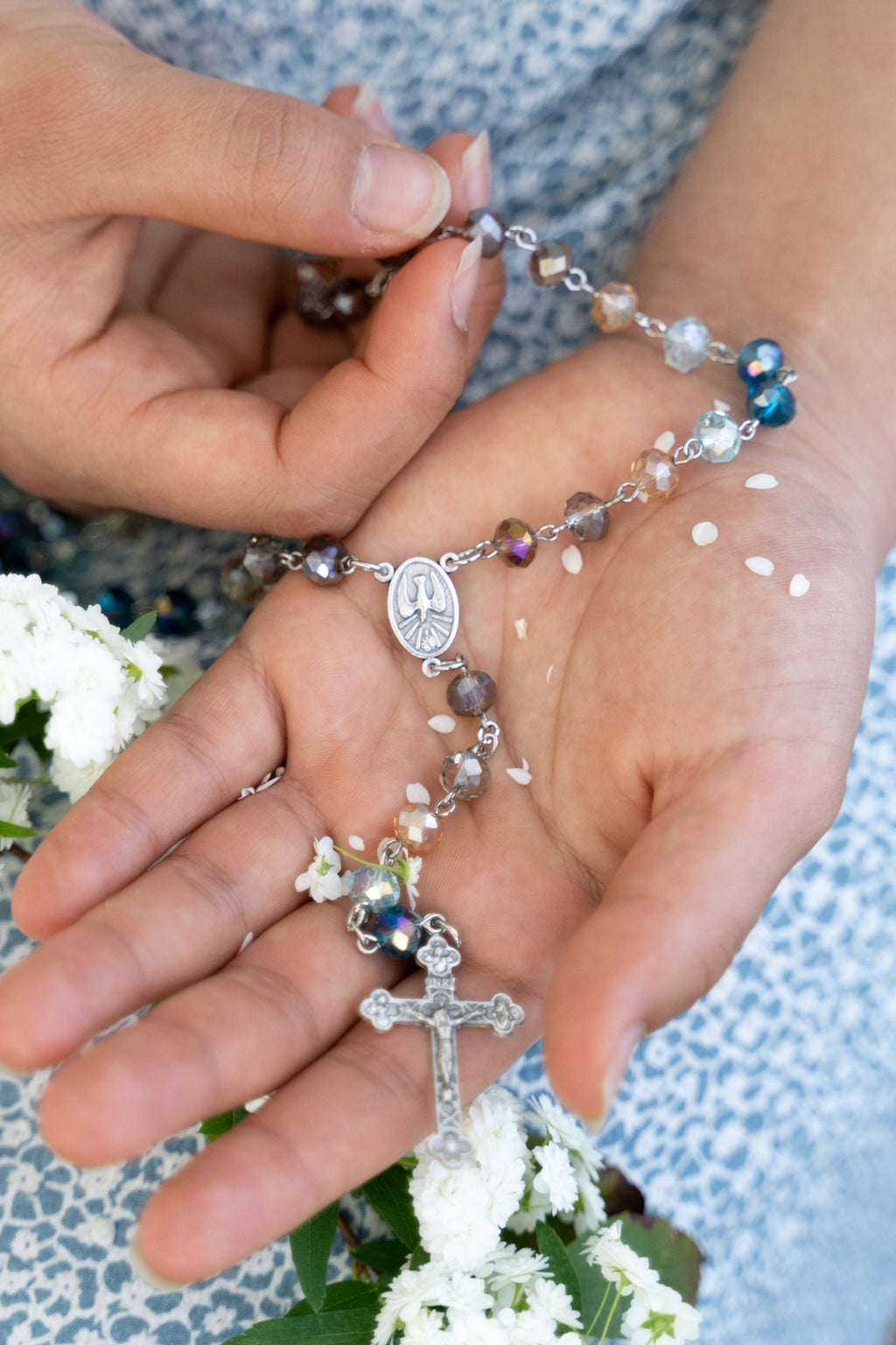 Close-up of hands holding a rosary with a blurred background